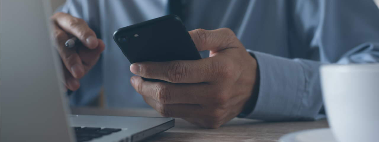 Man using computer and smart phone.