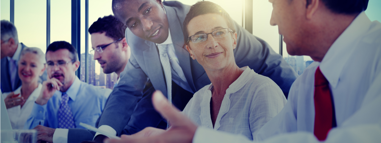 Business Strategies Business people gathered around table talking to each other