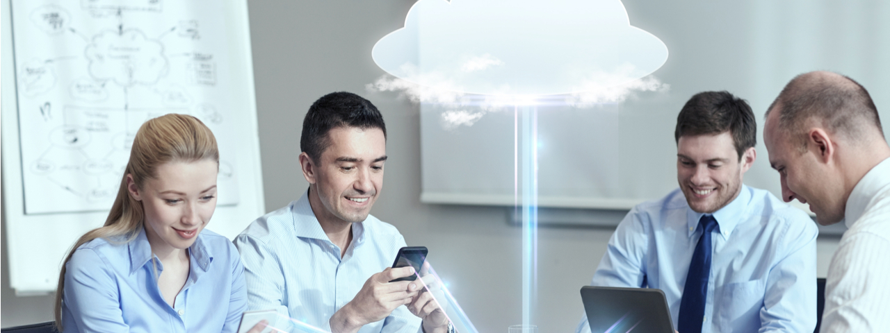 Four business people using computers or phones connected by cloud